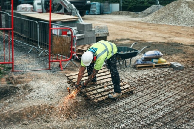 Person cutting metal on a warm building site